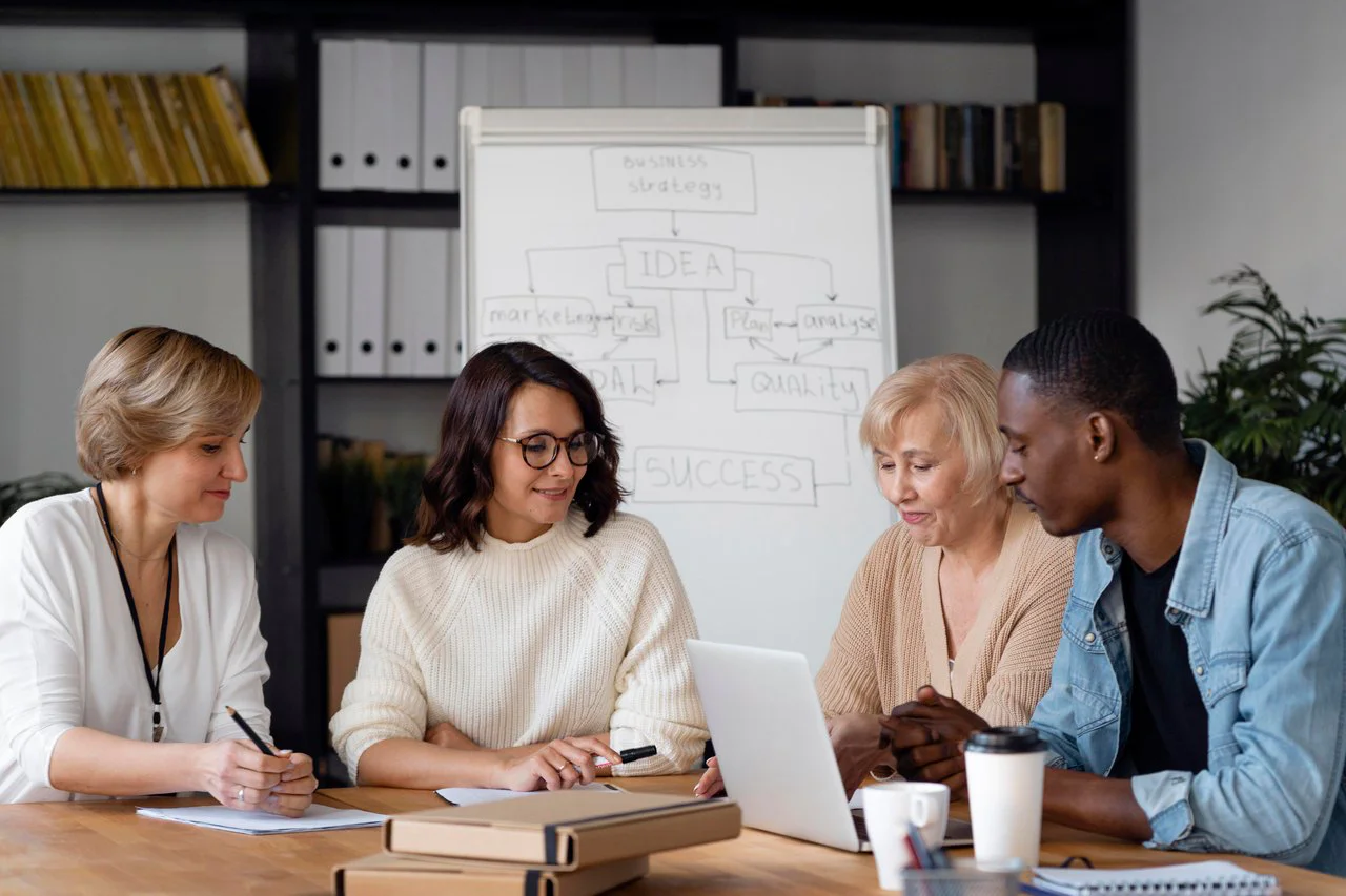 Personen besprechen sich am Meetingtisch